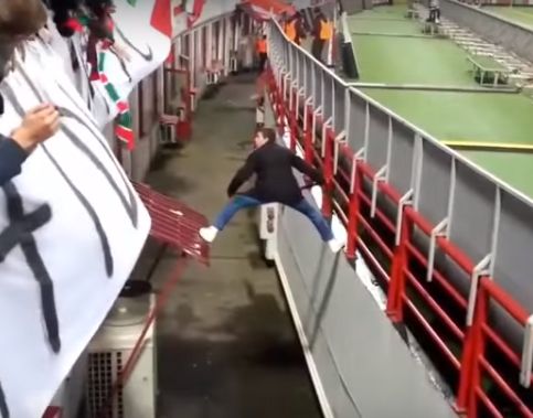 A Lokomotiv Moscow pitch invader uses his scarf to climb back into the stands during the 1-1 Europa League draw with Beşiktaş