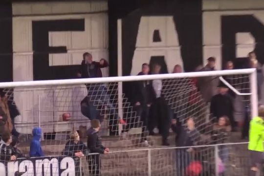 Maidenhead United fan heads ball to protect woman in stands from free kick