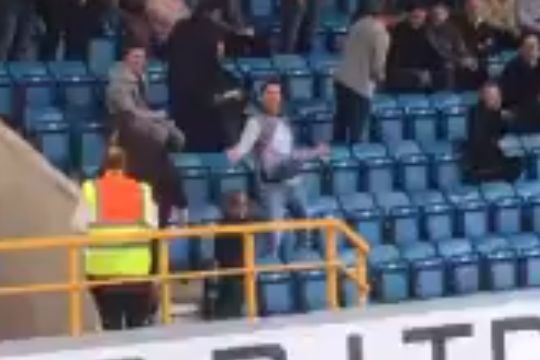 A Leeds fan dances in the stands at Millwall before their 1-0 defeat