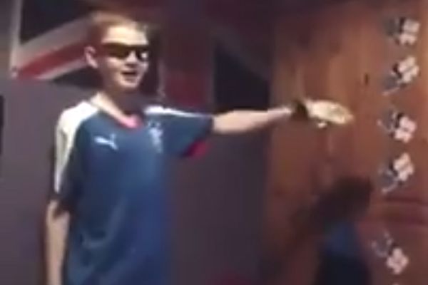 A young Rangers fan punches a wardrobe in what could be his bedroom