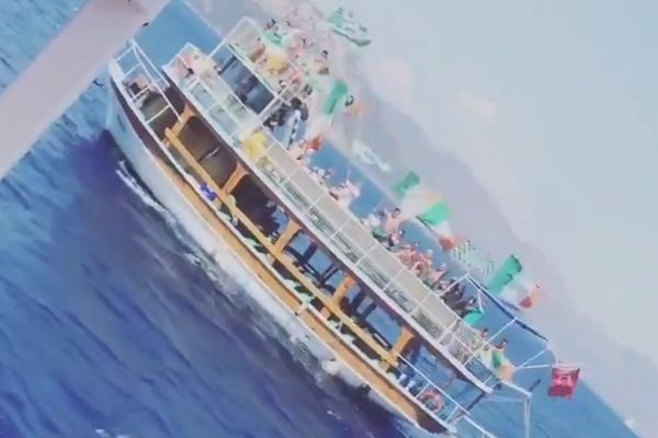 A boat of Celtic fans sail past a boat of Rangers fans off the coast of Turkey
