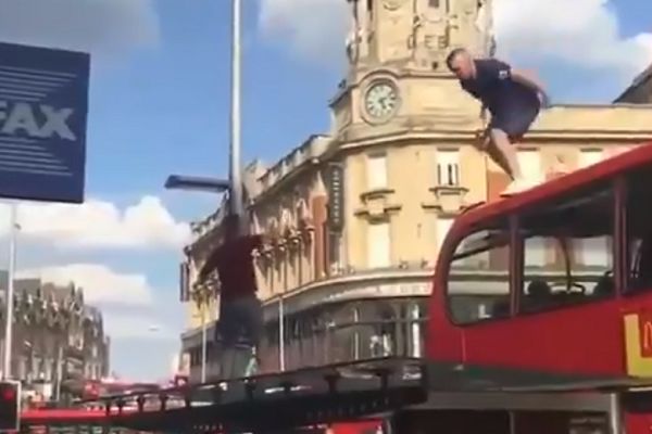 An England fan jumps off a London double-decker bus and crashes through the roof of a bus stop