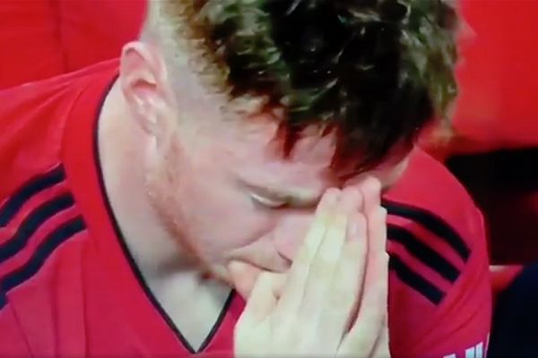 A Manchester United fan prays in the stands at Old Trafford during their 0-3 defeat to Tottenham