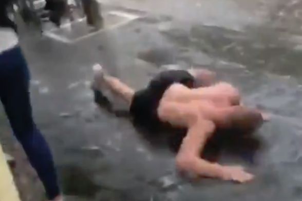 Shirtless England fan swims along the pavement in the rain in Spain for a Nations League game