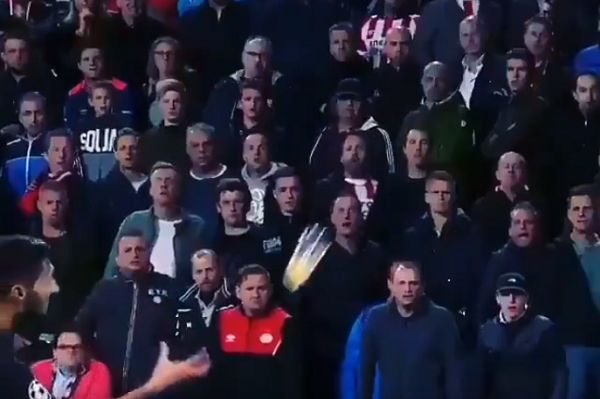 Inter's Matteo Politano catches a beer thrown at him by PSV Eindhoven fans