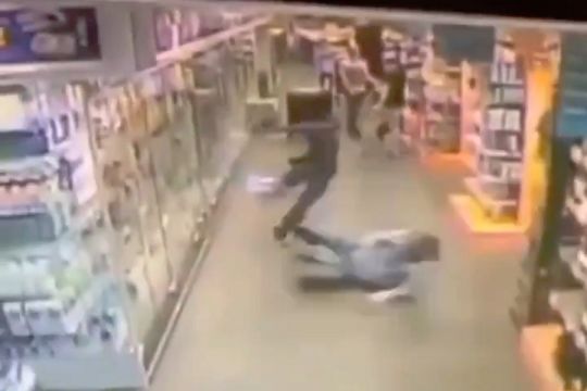 A shoplifter is slide tackled by a store employee