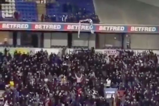 Bolton fans cheer as an 'Anderson Out' protest banner is thrown up to the upper tier of the stand