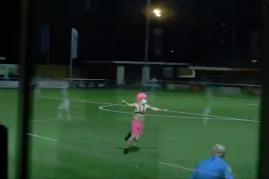 A shirtless pitch invader with a pink wig during an Eredivisie Vrouwen match between Twente and Achilles '29