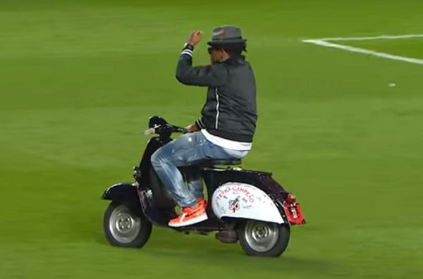 Eliseu rides a scooter on the pitch during celebrations after his former Benfica teammates won the title
