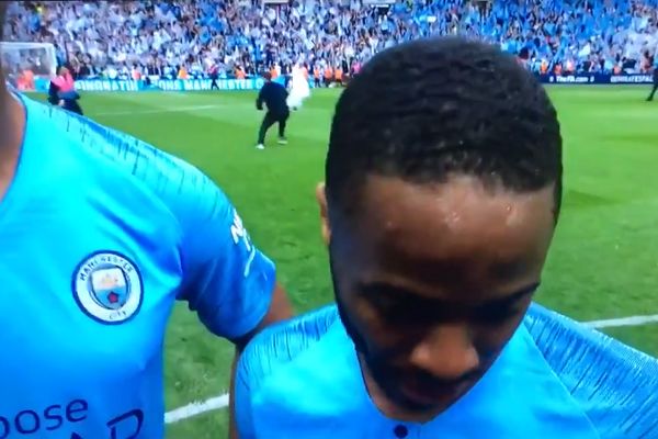 Pitch invader runs away from stewards behind Raheem Sterling's post-match interview after FA Cup final between Man City and Watford
