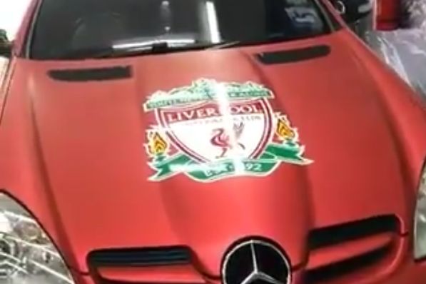 A Liverpool fan's customised red Mercedes car with club badges across it
