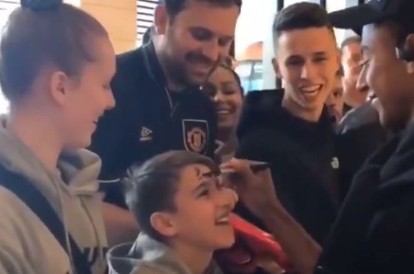Jesse Lingard signs a young fan's forehead during Manchester United's pre-season tour in Australian