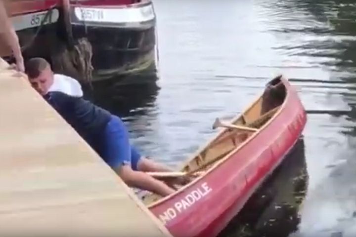 Newcastle fan clings on to the side after getting his feet stuck in a boat in Norwich