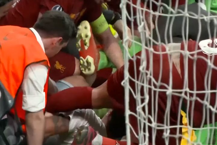 Pitch invader slides into the Liverpool players after they won the Super Cup on penalties, injuring goalkeeper Adrián