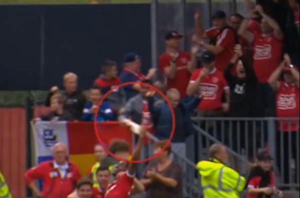 Almere City's Shayon Harrison catches beer thrown from stands after scoring against Go Ahead Eagles