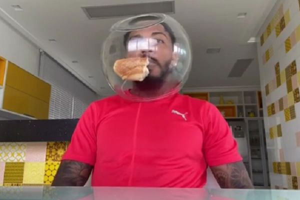 Santos player Marinho eats food with goldfish bowl over his head after sneeze skit