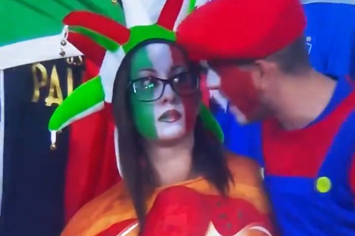 Italy fan in pizza costume spoken to by supporter dressed as Mario at Euro 2020 final